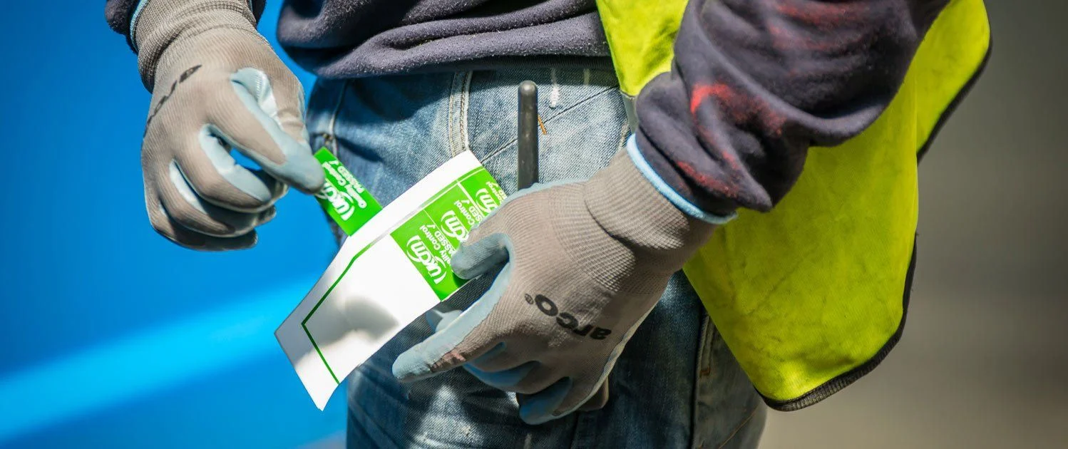 A UKCM fitter applying a safety label